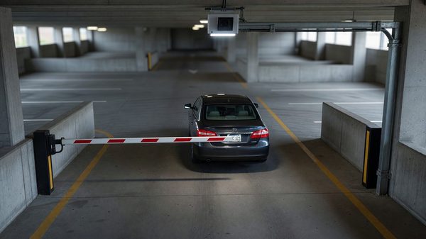 Overhead camera reading a vehicle license plate at a parking garage entry lane